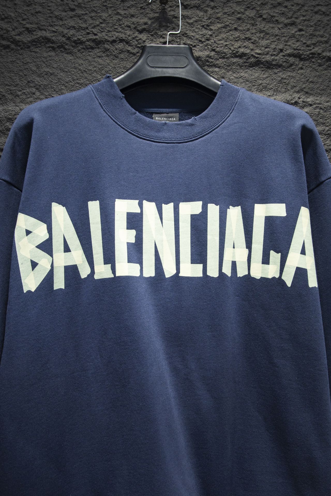 Blue sweatshirt with large white Balenciaga logo across chest