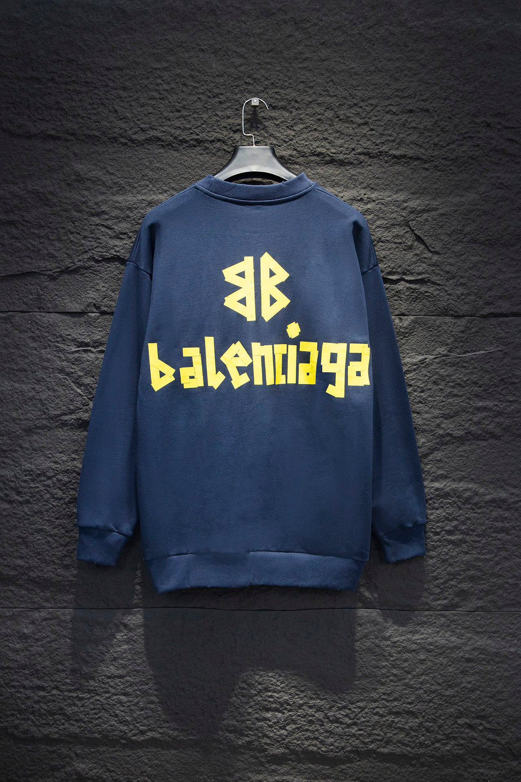 Blue sweatshirt with yellow Balenciaga-style logo text on back