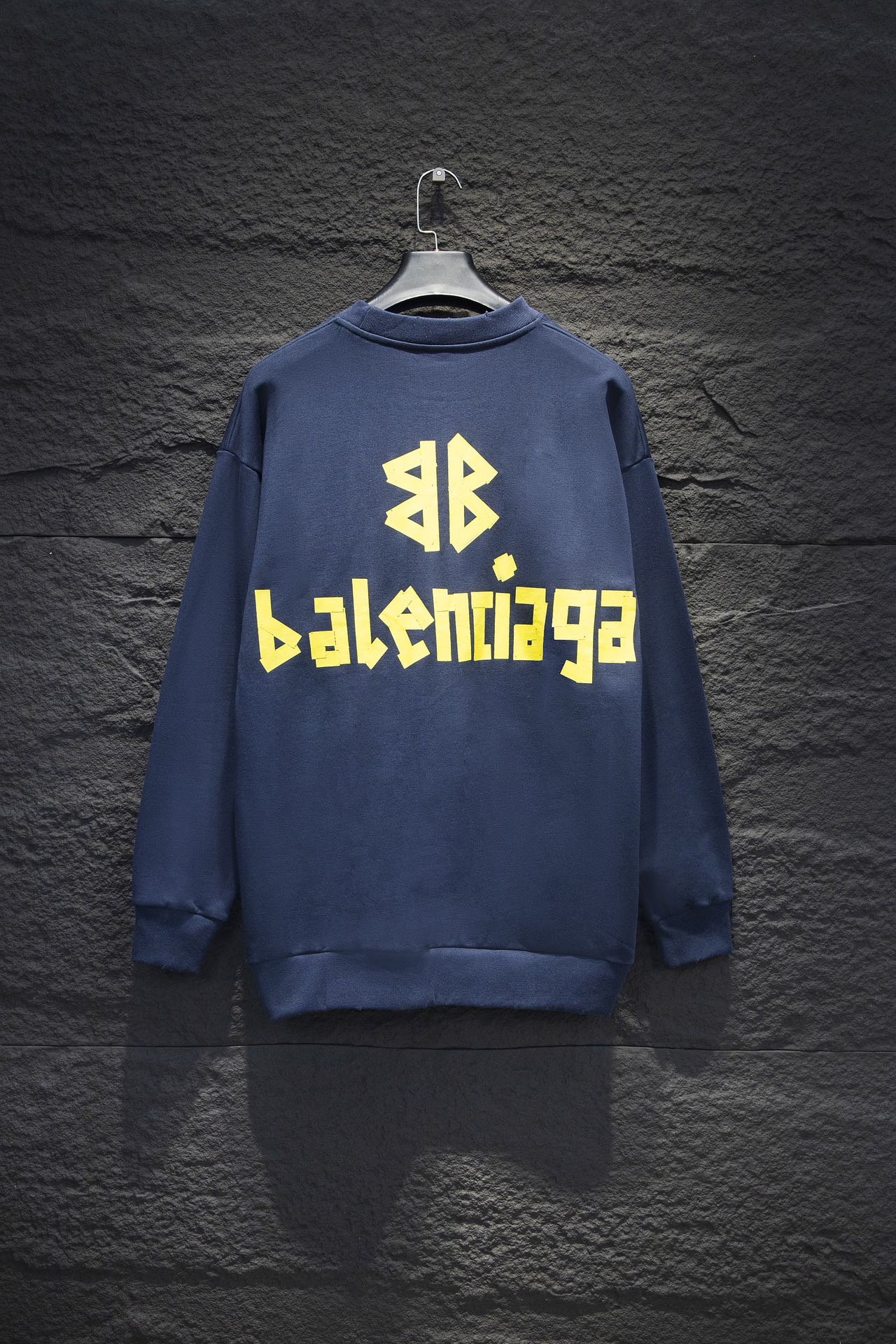 Blue sweatshirt with yellow Balenciaga-style logo text on back