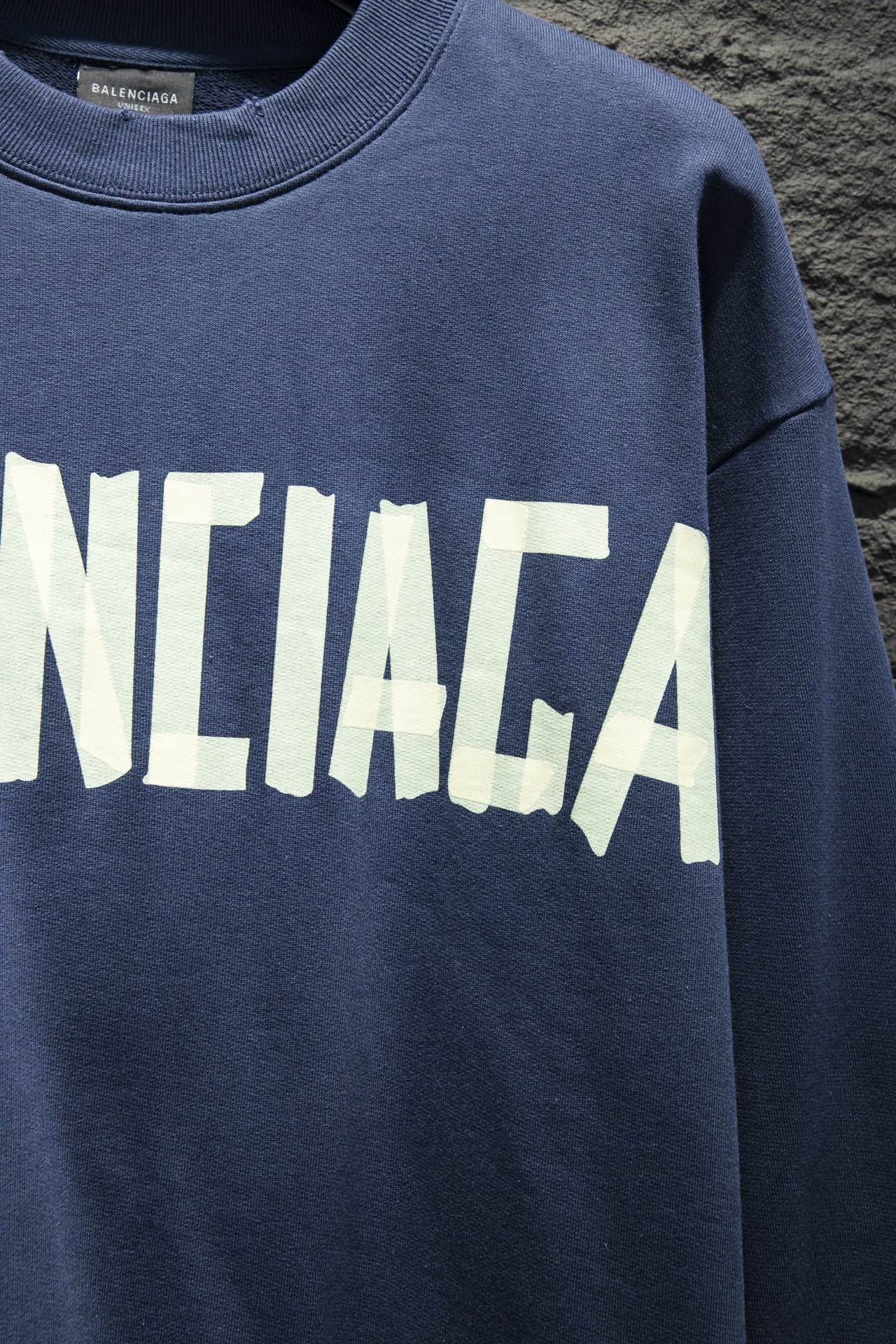 Blue sweatshirt with partial white Balenciaga logo lettering