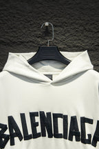 White hoodie hood and drawstring with large Balenciaga logo across chest