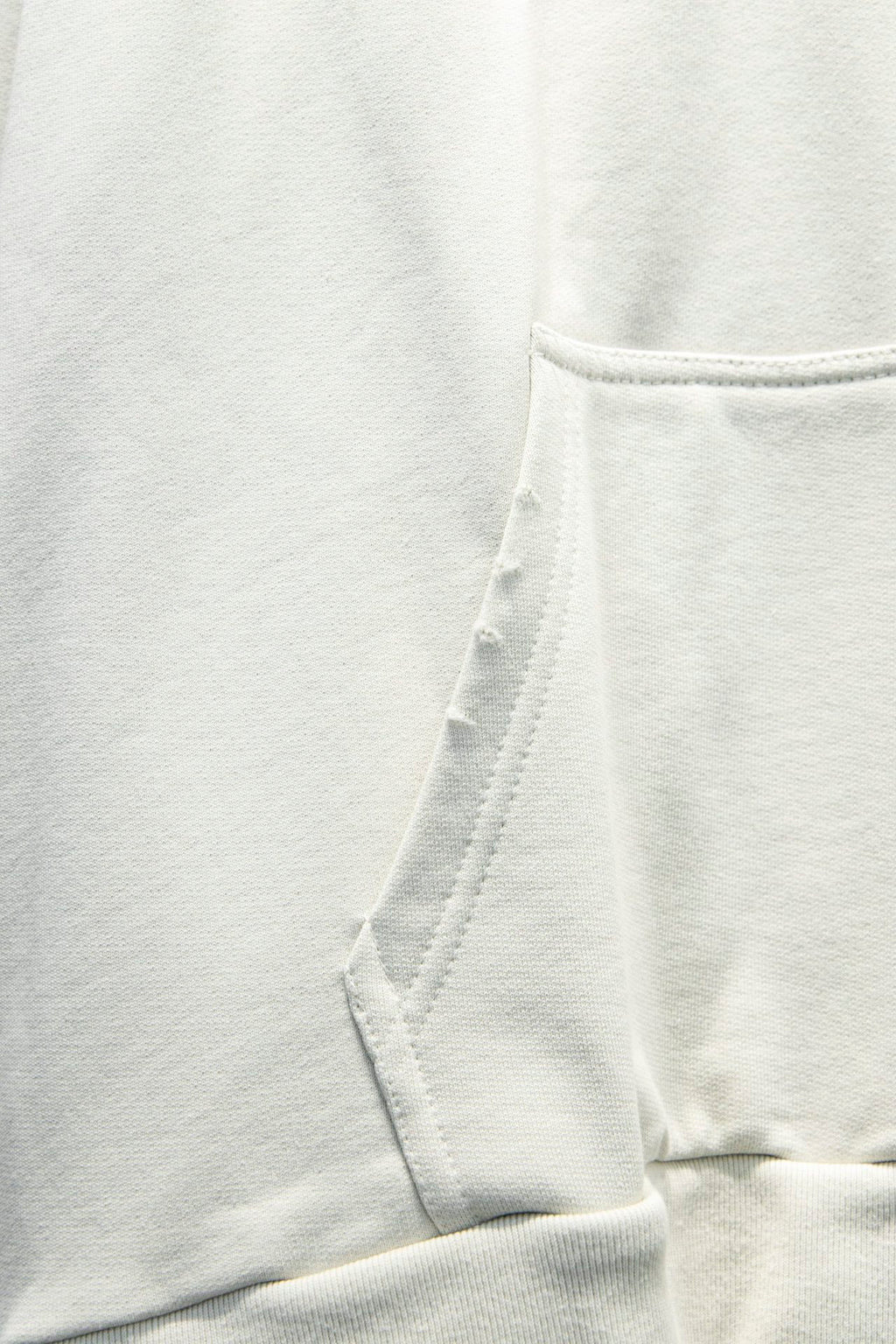 White hoodie fabric with stitched hood seam and drawstring opening