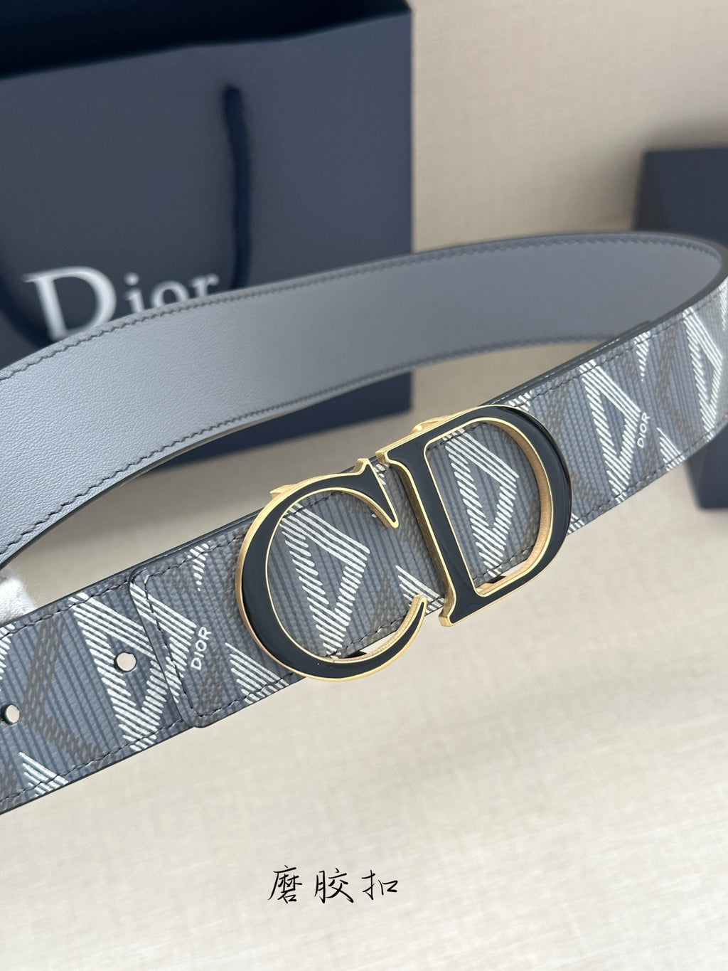 Designer belt with light gray monogram strap and gold-tone CD-style double buckle