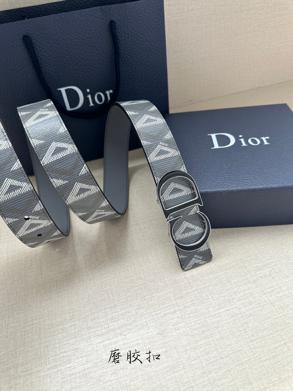 Designer belt with monogram strap and silver-tone double buckle, strap coiled