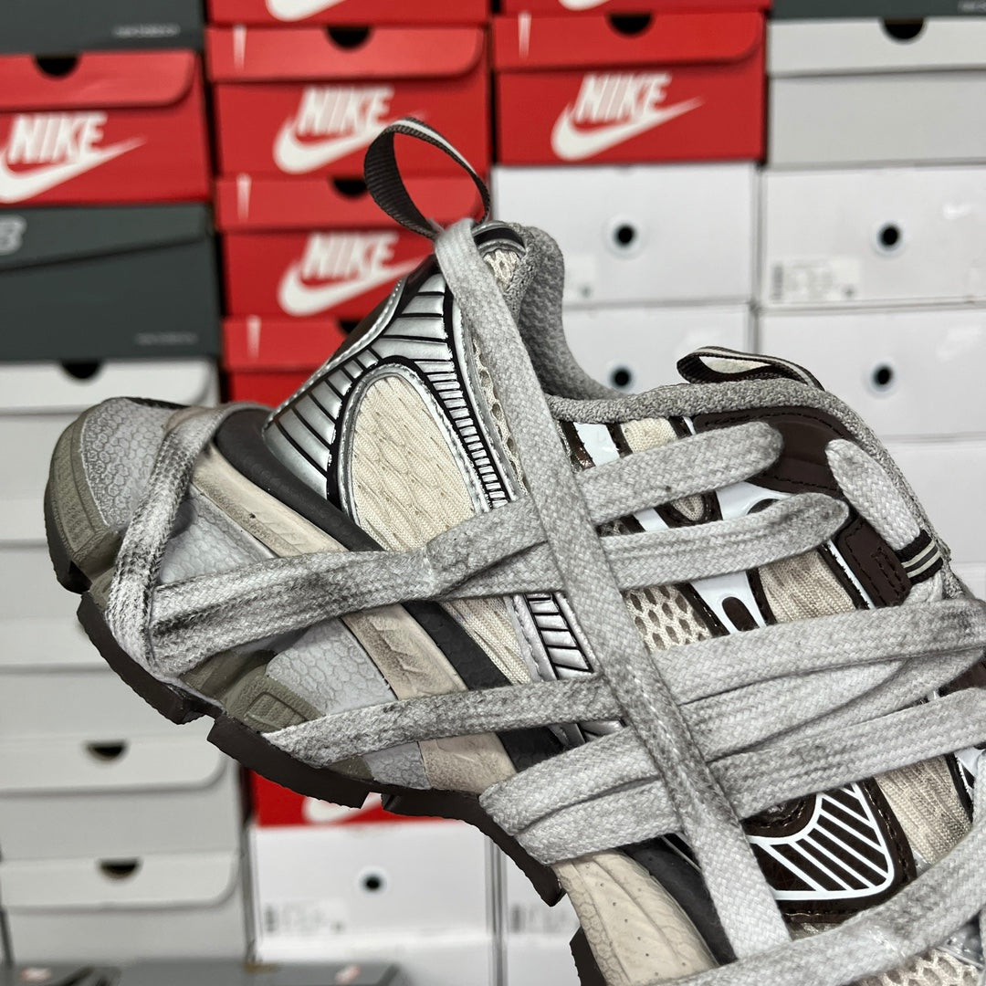 Gray sneaker quarter view with textured lace overlays and black side trim
