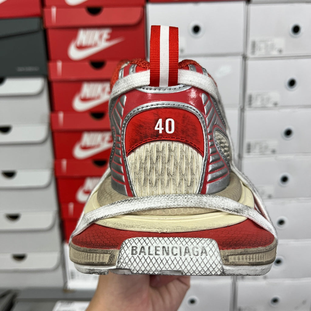 Unisex sneaker rear view with red heel tab and beige sole, white logo text