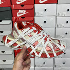 Unisex sneaker with red and beige patterned upper, white laces, and thick sole