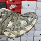 Side of lace-up sneaker with patterned panels and oversized logo detail.