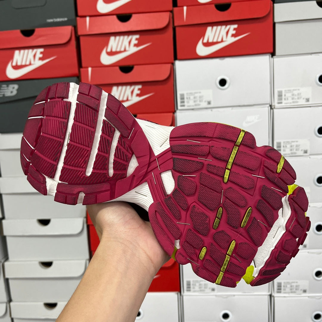 Rubber outsole of multicolor sneaker with maroon tread and lime edges