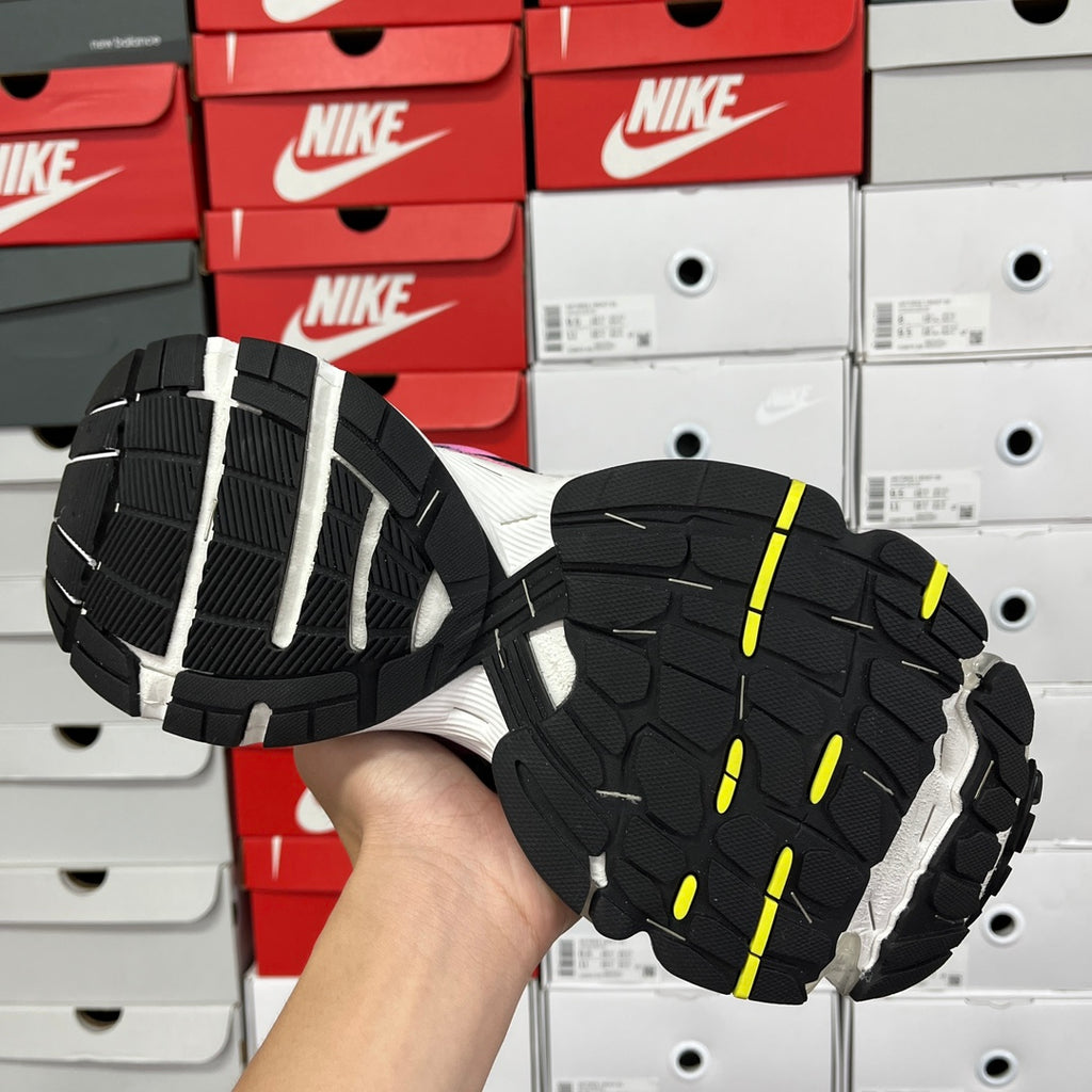 Unisex running shoe outsole, black tread with white sections and neon yellow highlights.