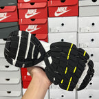 Unisex running shoe outsole, black tread with white sections and neon yellow highlights.
