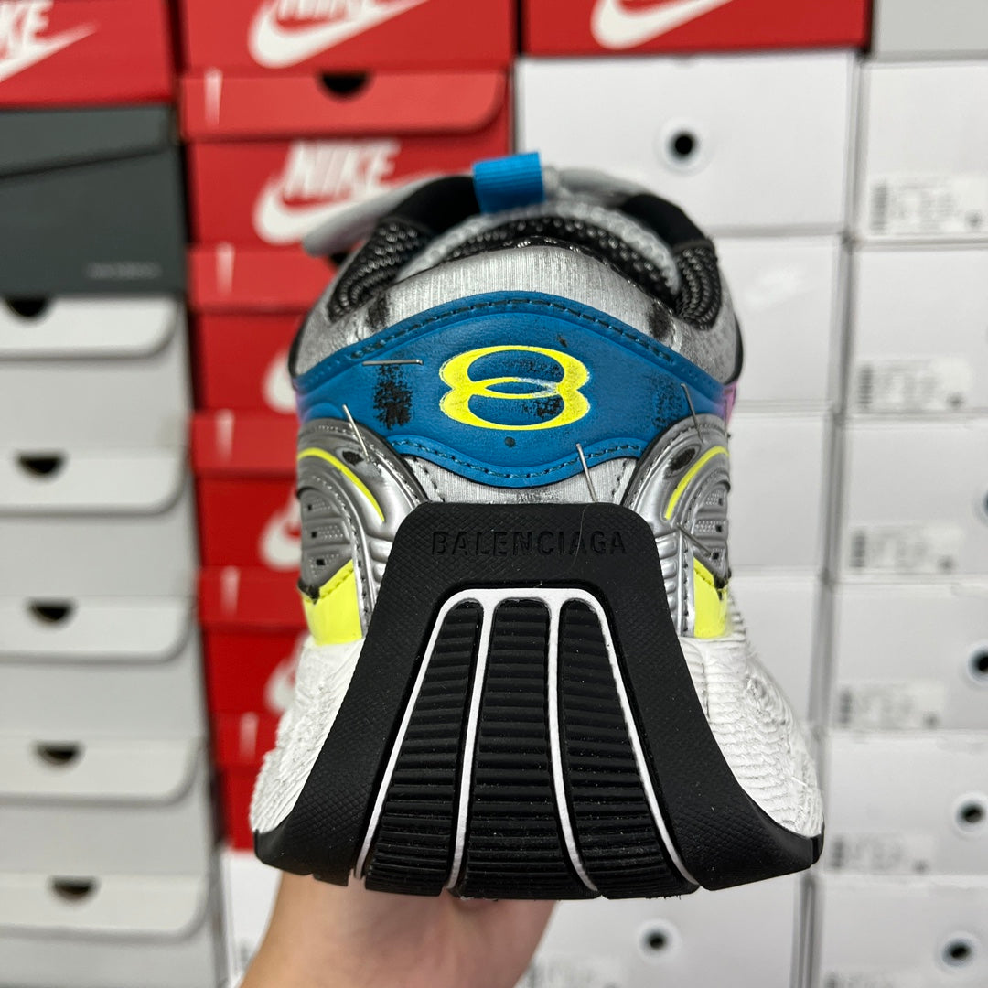 Unisex running shoe heel view, white sole with Balenciaga branding on black tread.