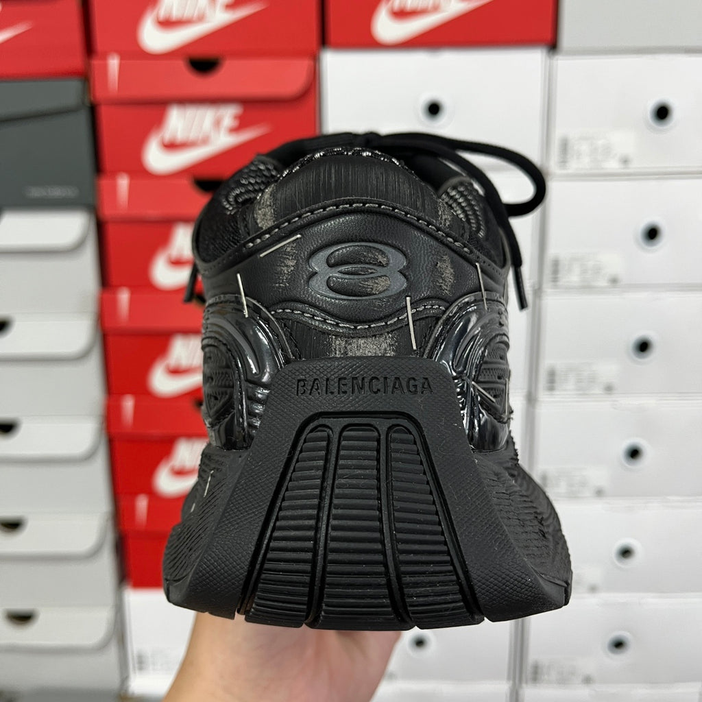 Black athletic sneaker heel with BALENCIAGA branding and ribbed sole edge, back view
