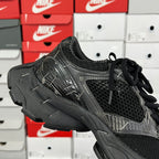 Black mesh athletic sneaker with black laces and textured overlays, side view