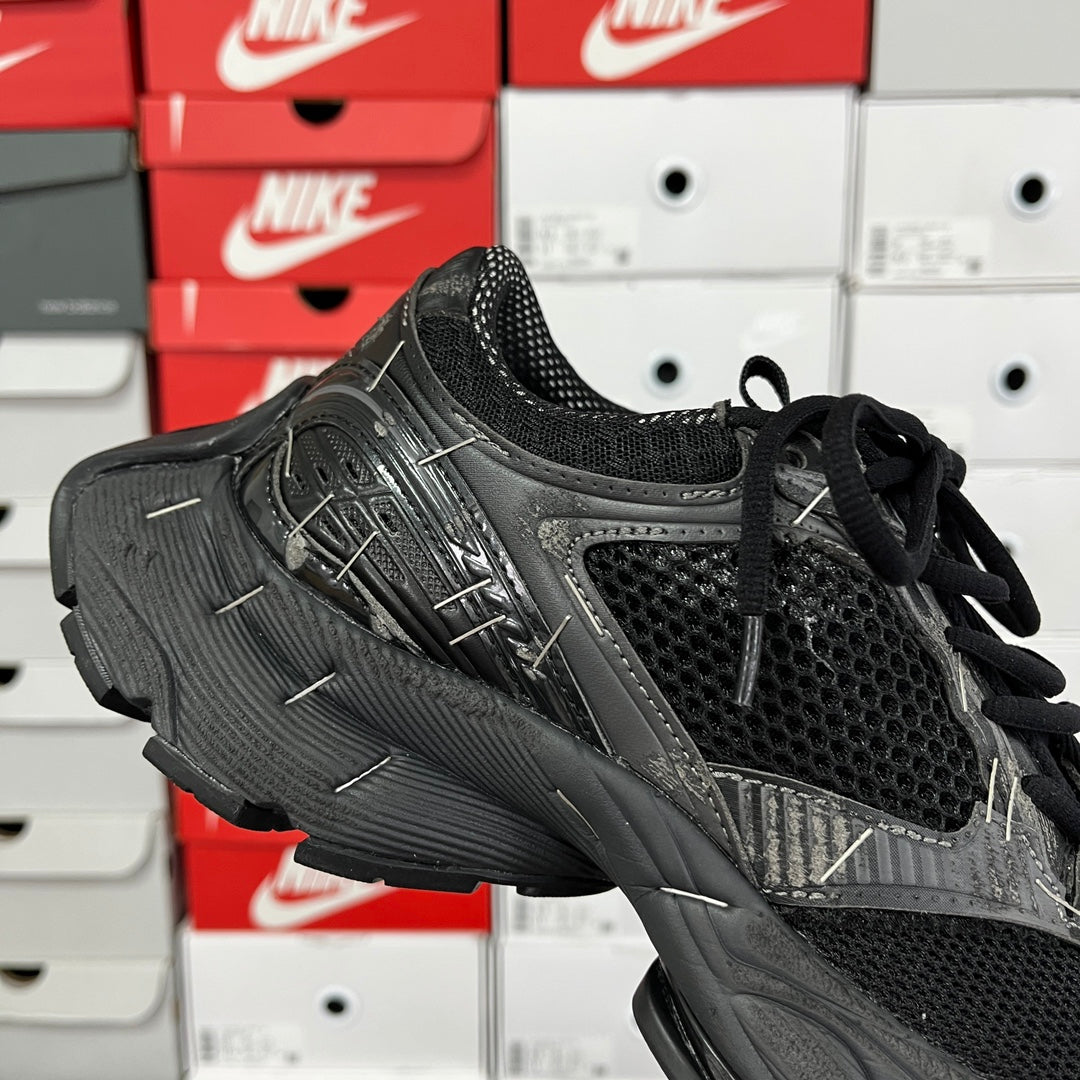 Black mesh athletic sneaker with black laces and textured overlays, side view