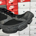 Black mesh athletic sneaker with stitched overlays and black laces, side close-up