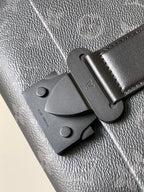 Louis Vuitton bag clasp and strap tab, dark leather, textured finish, metal hardware.