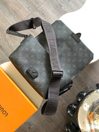 Louis Vuitton tote-style bag with flap, dual top handles, dark monogram canvas, strap.