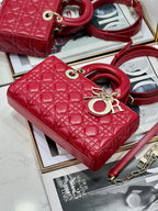 Dior red quilted handbag with top handle, gold hardware, and shoulder strap