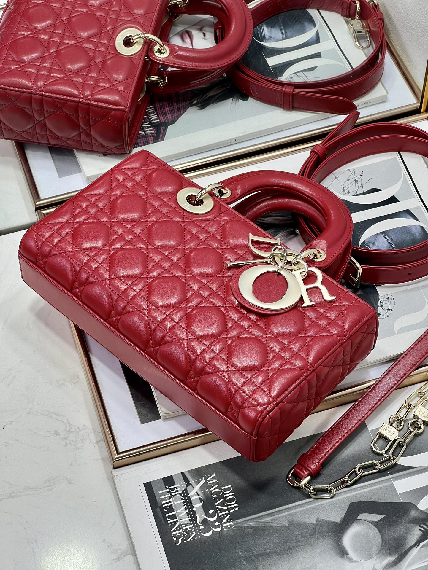 Dior red quilted handbag with top handle, gold hardware, and shoulder strap