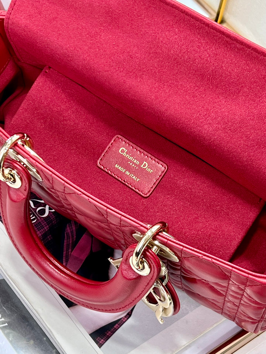 Dior red quilted handbag interior with leather brand patch and chain hardware