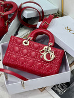 Dior red quilted handbag with top handles, front logo charm, and crossbody strap