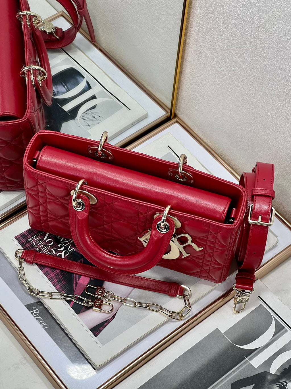 Dior red quilted handbag with long shoulder strap and front logo charm