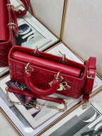 Dior red quilted handbag with long shoulder strap and front logo charm