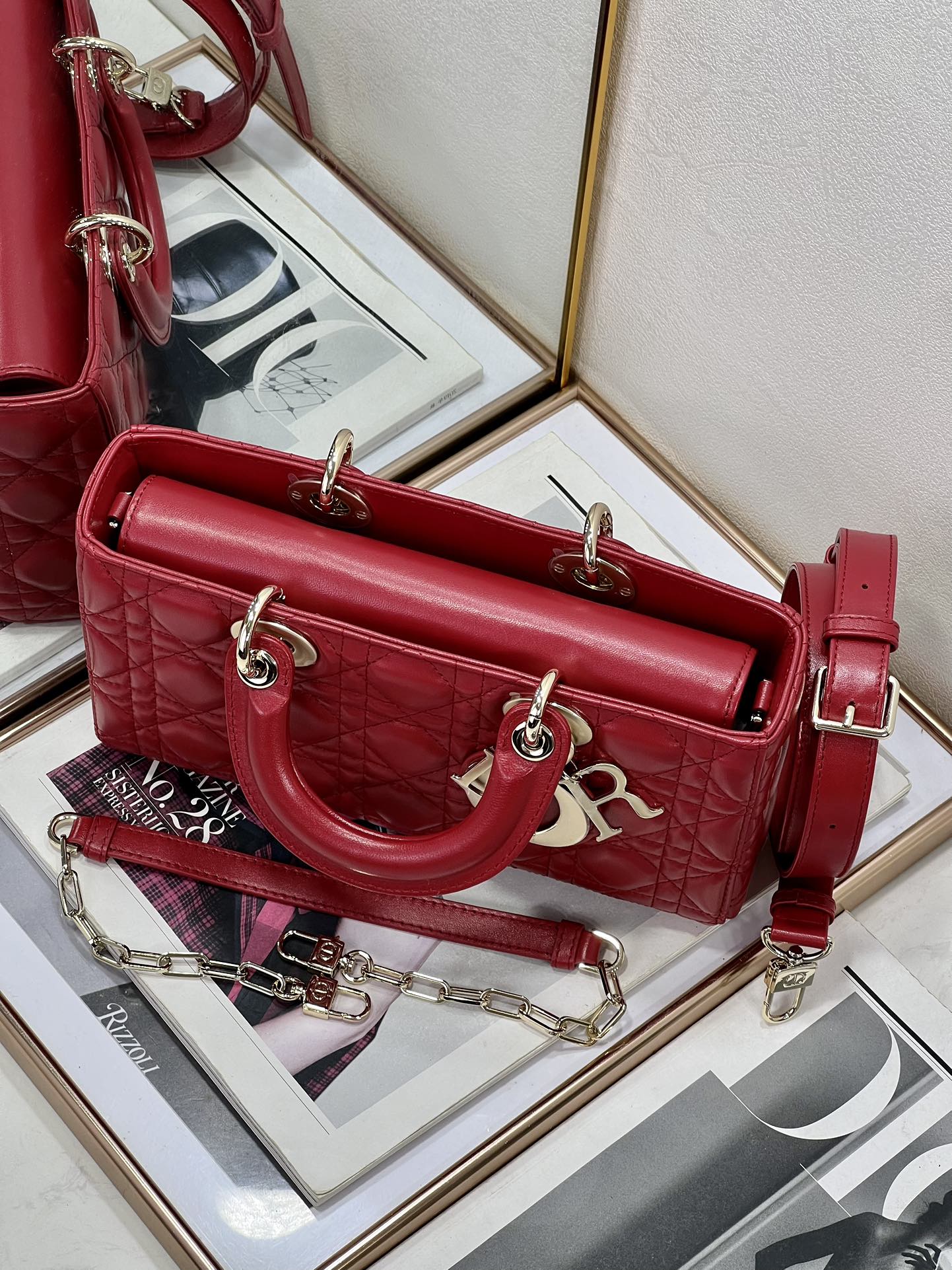 Dior red quilted handbag with long shoulder strap and front logo charm