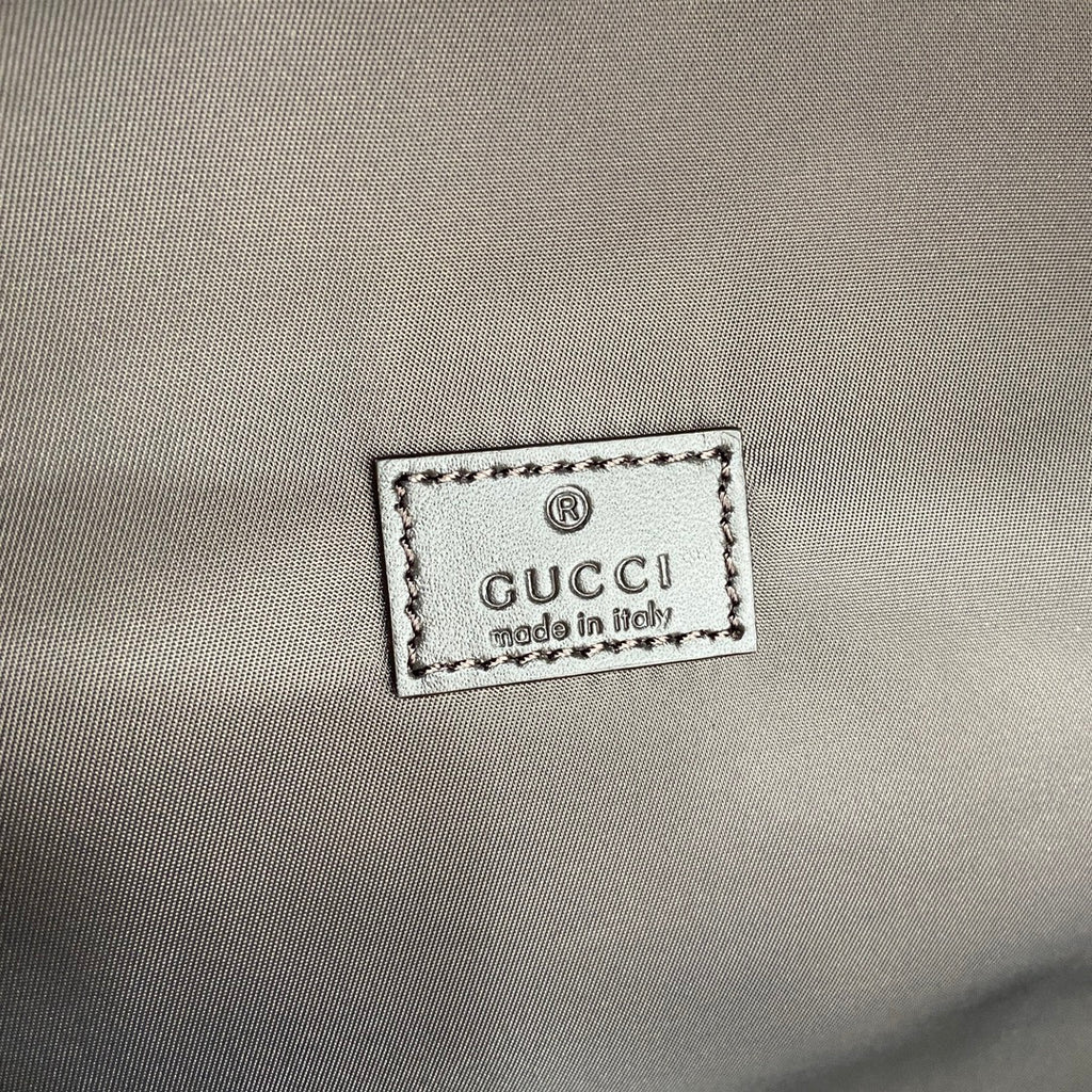 Gucci lining label with Gucci logo and “made in Italy” text on gray fabric