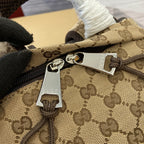 Gucci men's backpack zipper pull with engraved metal hardware on GG fabric