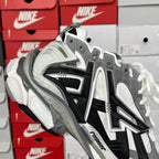 Balenciaga lace-up sneakers with gray uppers, black stripes, and white laces