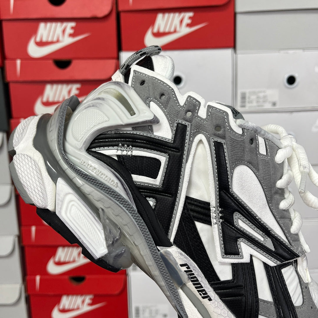 Balenciaga lace-up sneakers with gray uppers, black stripes, and white laces