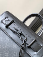 Louis Vuitton monogram handbag close-up with front hardware and stitched strap, dark gray.