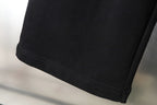 Black pants hem with stitched edge and side seam detail