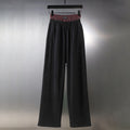 Black wide-leg pants with elastic waistband and red plaid inner band