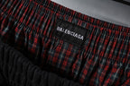 Balenciaga logo patch on red plaid waistband area of black pants