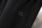 Black pant leg with small Balenciaga logo print on the fabric