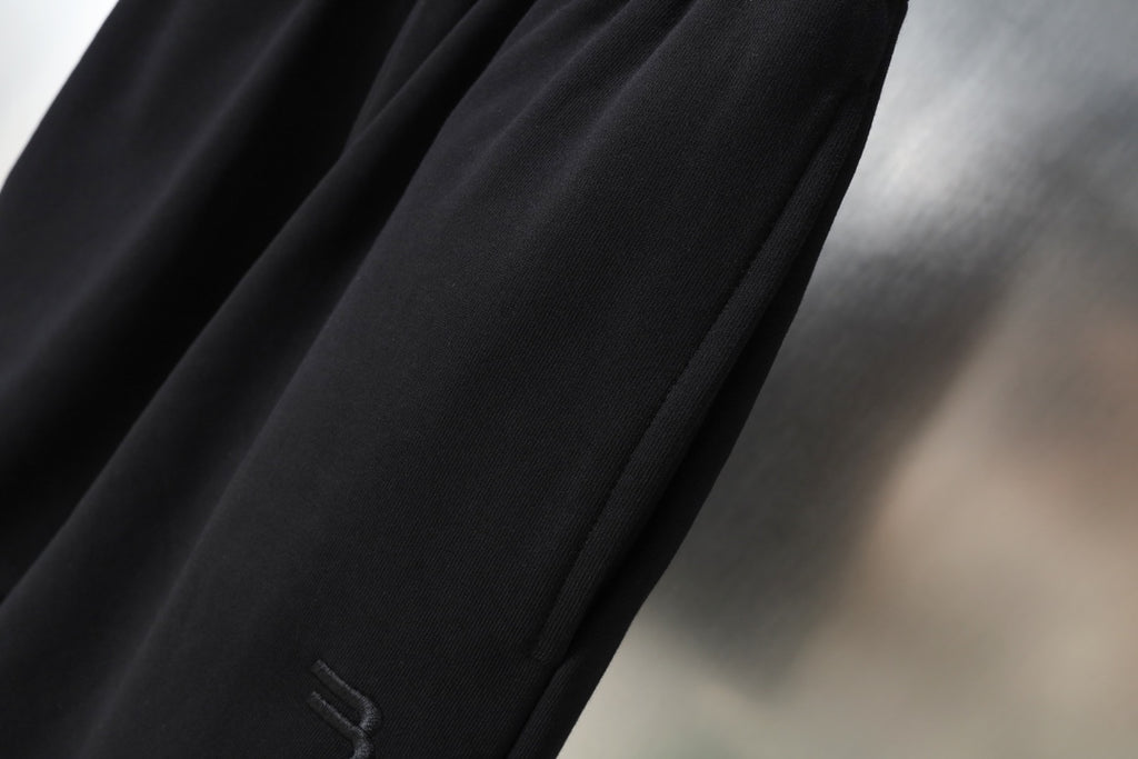 Black shorts with smooth drape fabric and side crease detail