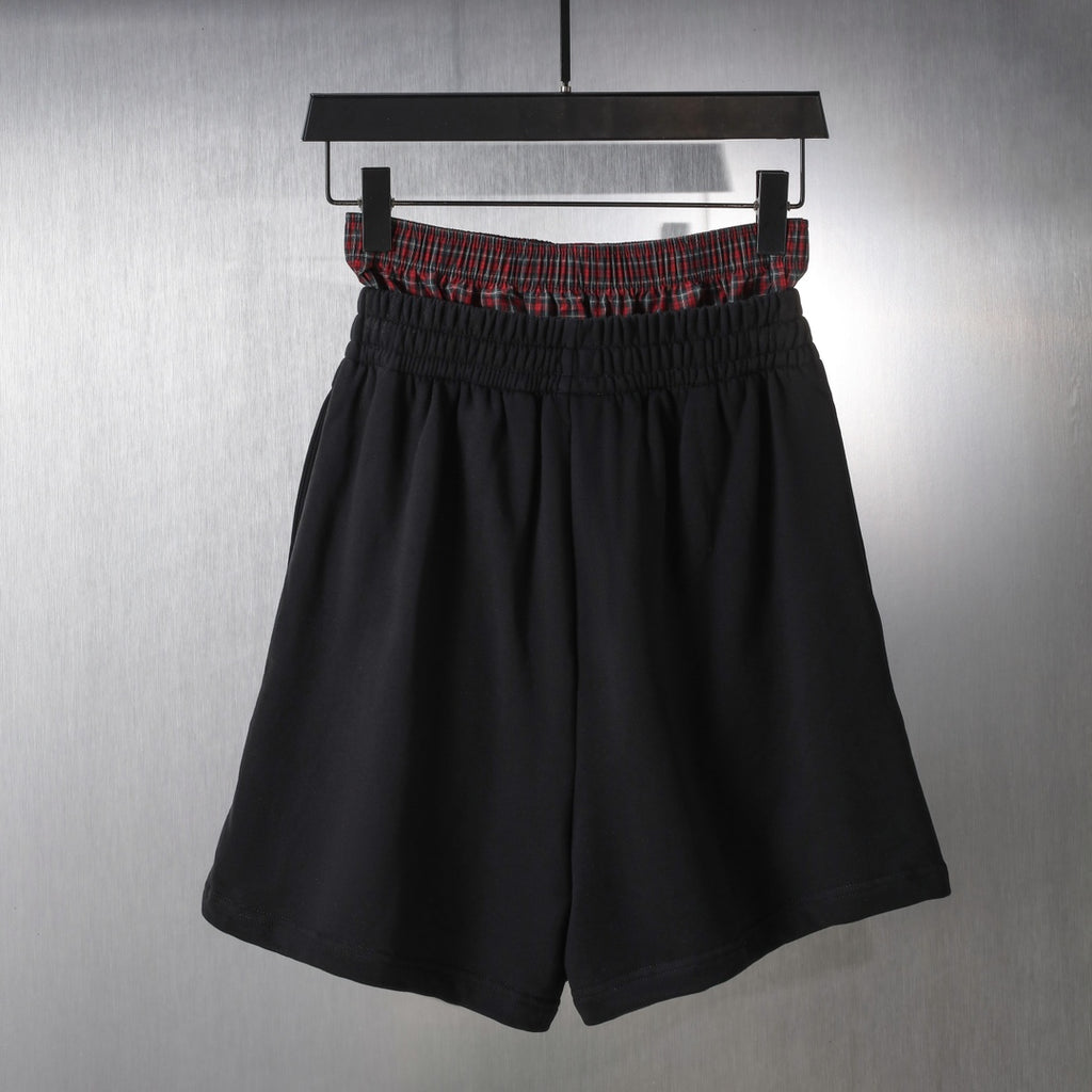 Black elastic-waist shorts with red plaid waistband trim