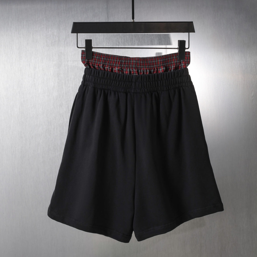 Black elastic-waist shorts with red plaid waistband trim