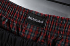 Black shorts with BALENCIAGA printed on red plaid waistband lining