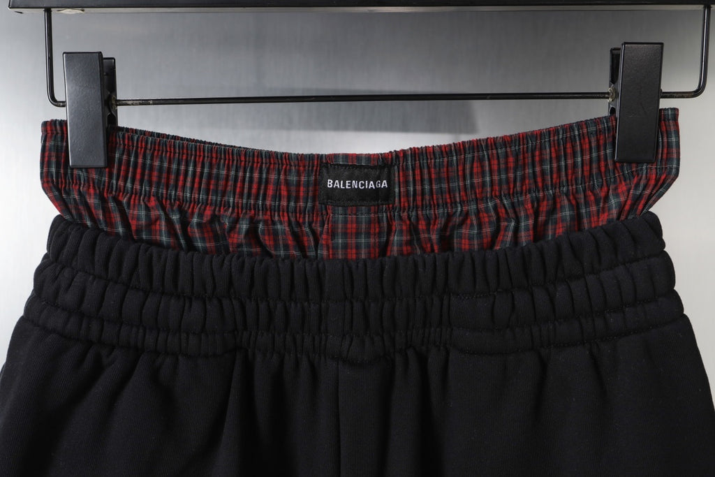 Black shorts waistband with gathered elastic and red plaid inner trim