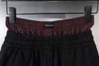 Black shorts waistband with gathered elastic and red plaid inner trim