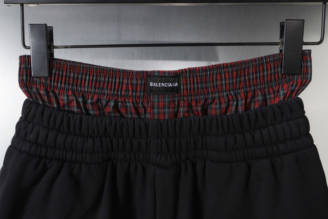 Black shorts waistband with gathered elastic and red plaid inner trim