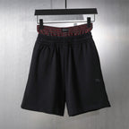 Black elastic-waist shorts with red plaid waistband trim