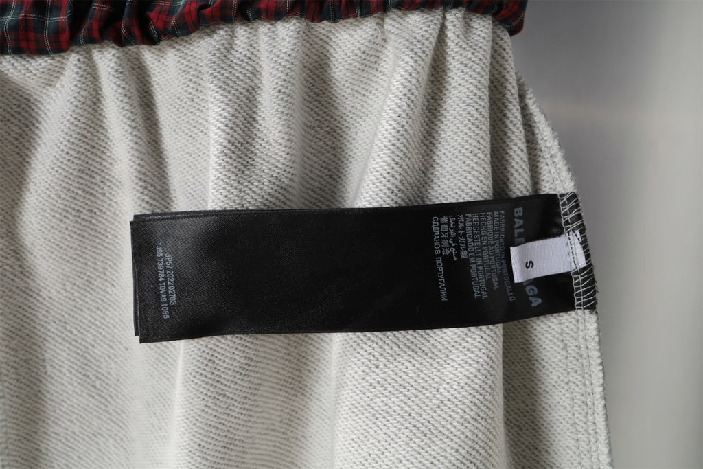 Grey shorts with black size label attached at inner waistband.