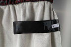 Grey shorts with black size label attached at inner waistband.