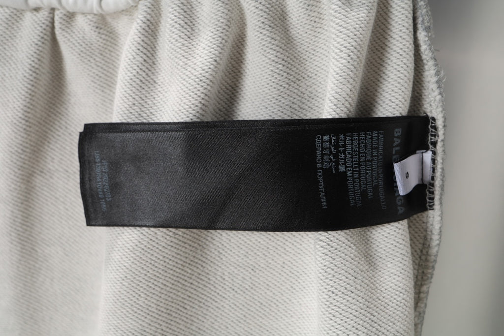 Grey sweat shorts with black care label tag on the inside waistband