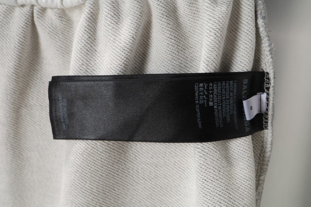 Grey sweat shorts with black care label tag on the inside waistband